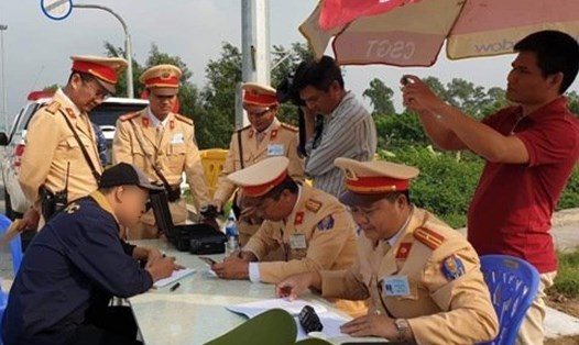 Lực lượng Cục CSGT tiến hành kiểm tra tài xế các xe tải trên tuyến đường cao tốc Hà Nội - Hải Phòng. Nguồn: báo Nhân Dân