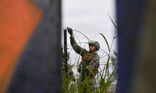 Binh sĩ Mỹ rải dây thép gai dọc theo đường biên giới với Mexico ở bang California. Ảnh: Reuters. 