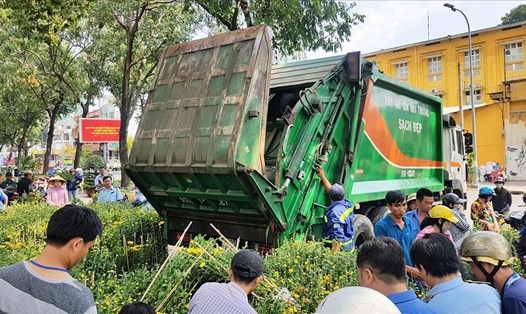 Cảnh chủ vườn kiên quyết vứt hoa lên xe rác chứ không cho người xin vào trưa 30 Tết tại Chợ Hoa Tết 2019 ở công viên 23/9. Ảnh: Trường Sơn