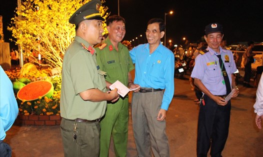 Chủ tịch LĐLĐ tỉnh Tiền Giang (thứ 2 từ phải sang) thăm lực lượng bảo vệ chợ hoa xuân TP Mỹ Tho trong đêm giao thừa.
