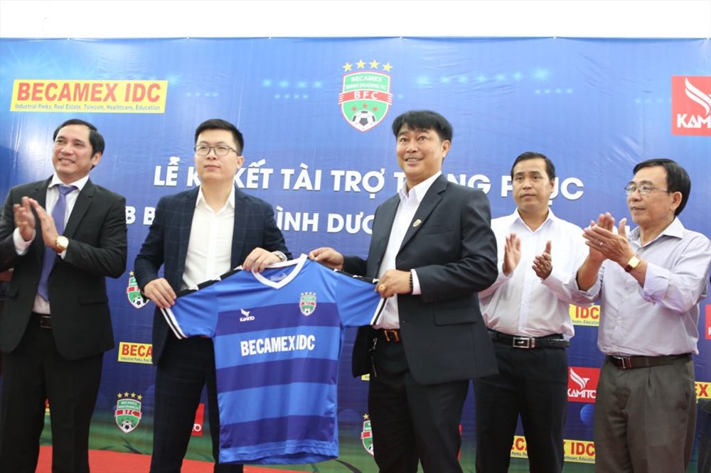 HLV Trần Minh Chiến cùng đại diện nhà trợ tại lễ ra mắt trang phục thi đấu mới của B. Bình Dương. Ảnh: Q.C