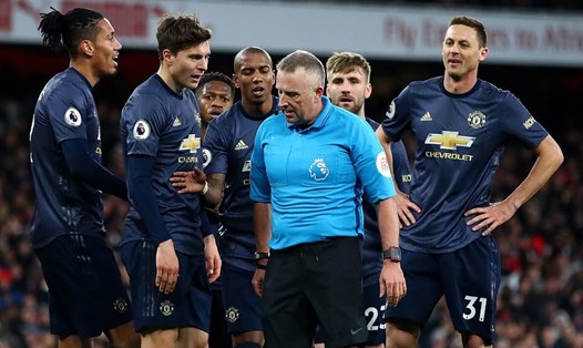 Các cầu thủ Man United vây lấy trọng tài Jon Moss (áo xanh) để phản đối quyết định thổi phạt đền của ông. Ảnh: Getty Images.