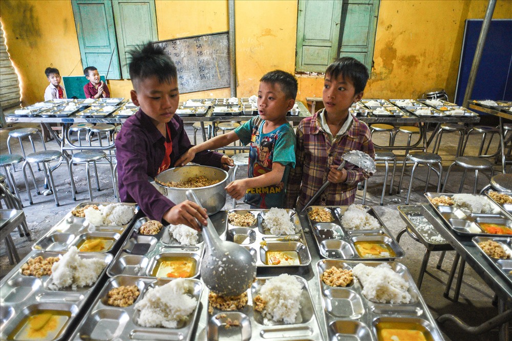 Các em bán trú sẽ được thầy cô chăm lo cho ba bữa ăn mỗi ngày, sáng ăn mì tôm, bánh mì, .. trưa và tối sẽ luôn có cơm, thịt và rau thay đổi tuỳ vào mỗi ngày. Trước mỗi bữa cơm, những học sinh lớp lớn cũng sẽ cùng các thầy cô chuẩn bị bữa đầy đủ cơm, thức ăn vào từng khay cho các bạn.