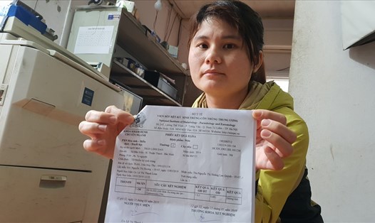 Chị Nguyễn Thị Vân và giấy xét nghiệm sán lợn của con gái.