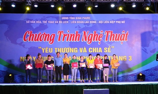 Ông Nguyễn Trung Dũng - Phó Chủ tịch LĐLĐ tỉnh Bình Phước (thứ 4 từ trái sang) trao quà của Cty TNHH Nike Việt Nam cho đoàn viên có hoàn cảnh khó khăn. Ảnh: N.V