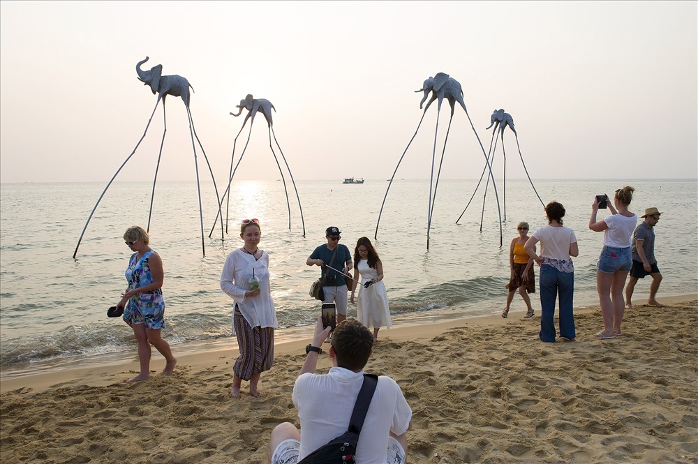 Du khách tham quan, chụp ảnh tại khu vực biển có mô hình những chú voi trên biển