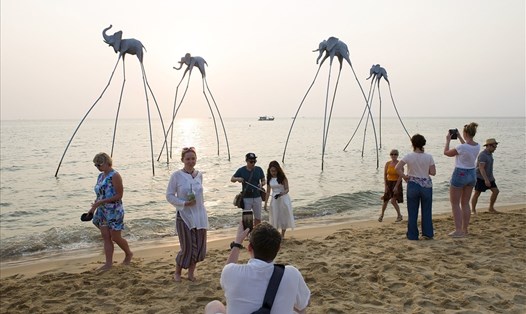 Du khách tham quan, chụp ảnh tại khu vực biển có mô hình những chú voi trên biển