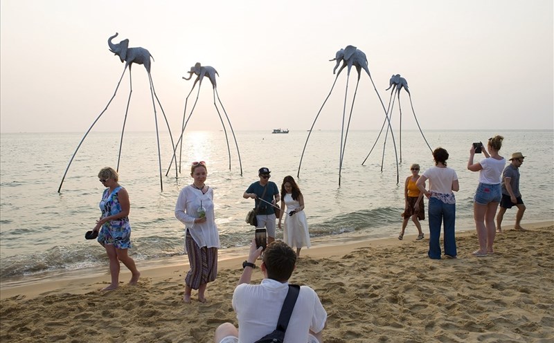 Du khách tham quan, chụp ảnh tại khu vực biển có mô hình những chú voi trên biển
