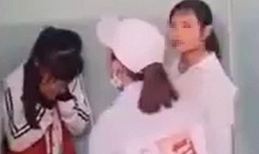 Nữ sinh lớp 7 (trái) bị vây đánh trong nhà vệ sinh ở Phú Yên, hôm 15/3. Ảnh: Cắt từ video.