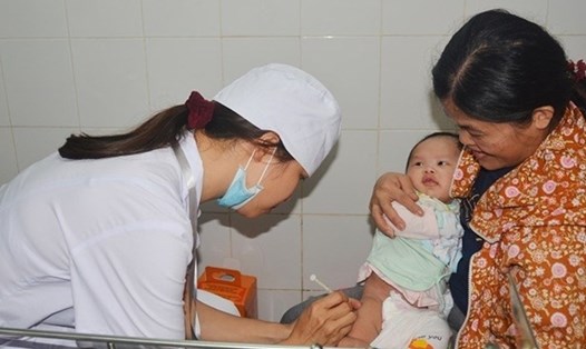 Phụ huynh đưa con trẻ đi tiêm vắc-xin phòng sởi.