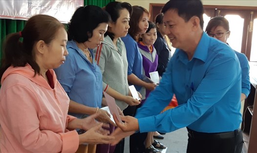 Ông Nguyễn Thái Thành (phải), Phó Chủ tịch CĐ  các khu chế xuất và công nghiệp TPHCM, trao quà cho các nữ CNLĐ. Ảnh Nam Dương
