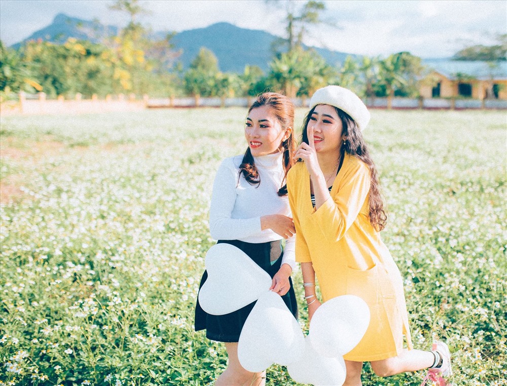 Các bạn trẻ chụp ảnh lưu niệm tại Sân bay Tà Cơn vào mùa hoa xuyến chi. Ảnh: ĐĂNG TÌNH