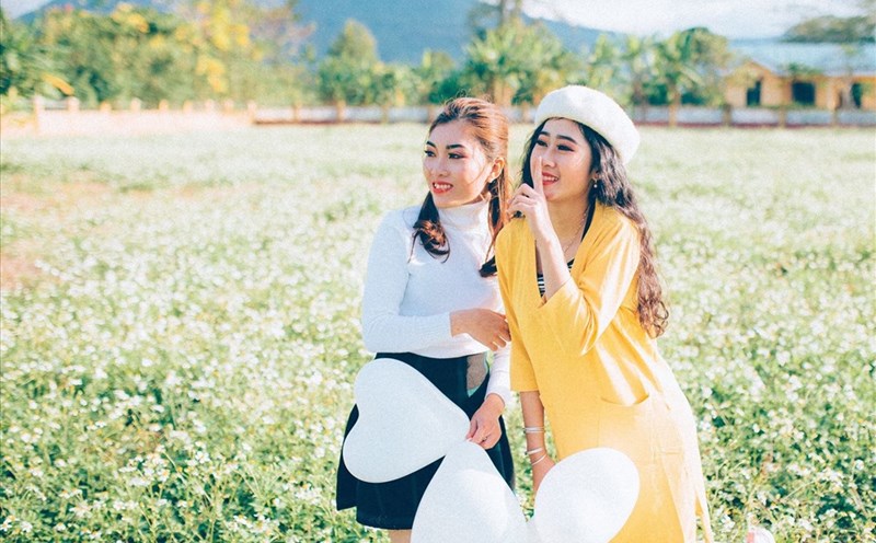 Các bạn trẻ chụp ảnh lưu niệm tại Sân bay Tà Cơn vào mùa hoa xuyến chi. Ảnh: ĐĂNG TÌNH