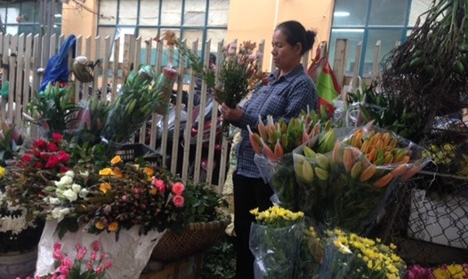 Chị Nguyễn Thị Hà,mặc dù đang bị đau đầu nhưng vẫn cố mang hoa ra phố bán ngày 8.3. Ảnh: MN