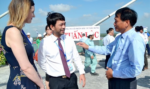 Ông Nguyễn Văn Dương (bìa phải) trao đổi với đại biểu nước ngoài tại buổi lễ hợp long cầu Cao Lãnh. Ảnh: Lục Tùng