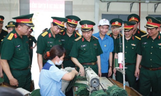 Đồng chí Trần Văn Thuật - Phó chủ tịch Tổng LĐLĐVN (đội mũ trắng) cùng lãnh đạo CTCP 26 tham quan xưởng sản xuất. Ảnh: HẢI NGUYỄN