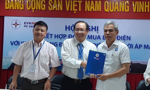 Đại diện Công ty Điện lực Sài Gòn trao hợp đồng mua điện cho hộ dân lắp đặt hệ thống điện mặt trời áp mái. Ảnh Nam Dương