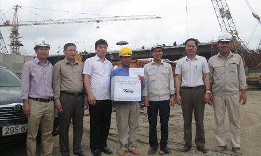 Đồng chí Quách Xuân Vinh (thứ 3 từ trái sang) trao quà cho tập thể cán bộ, kỹ sư, công nhân lao động trên công trường. Ảnh: V.C  