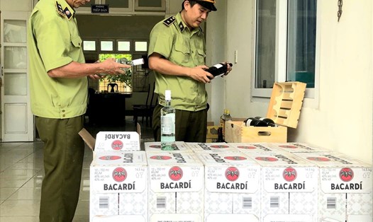 Lực lượng QLTT Quảng Bình kiểm tra số rượu lậu vừa bắt giữ. Ảnh: Lê Phi Long