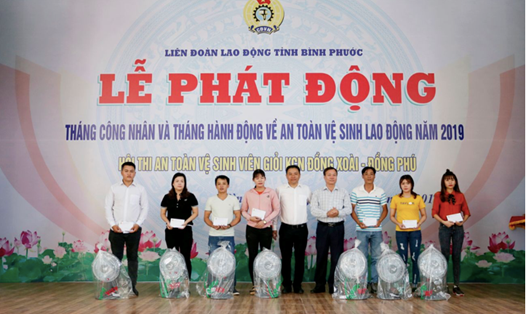 Ông Lê Quang Hùng, Giám đốc bán hàng toàn quốc của Mcredit (áo trắng – giữa) tặng quà cho công nhân lao động bị tai nạn lao động tại KCN Đồng Xoài, tỉnh Bình Phước.