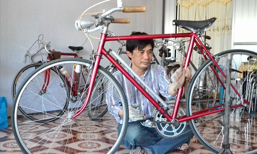 Ông Tuấn đang chăm sóc chiếc xe đạp trong bộ sưu tập xe đạp cổ của mình. Ảnh: Lục Tùng