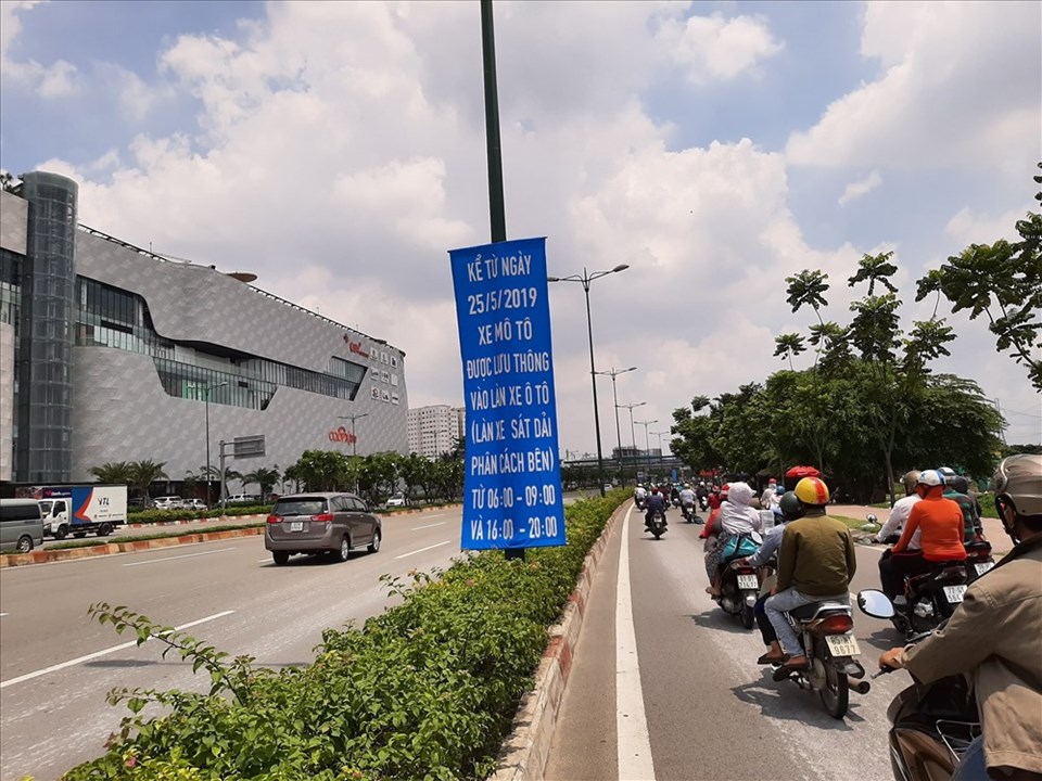 Băng rôn thông báo cụ thể về thời gian điều  xe máy chạy vào làn ô tô trên đường Phạm Văn Đồng.