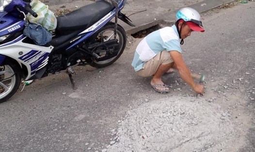 Hình ảnh người đàn ông đục mảng bê tông trên mặt đường "gây sốt" mạng xã hội.