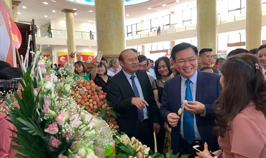 Phó Thủ tướng Vương Đình Huệ tham quan gian hàng và nếm thử vải. Ảnh Thành Chung.