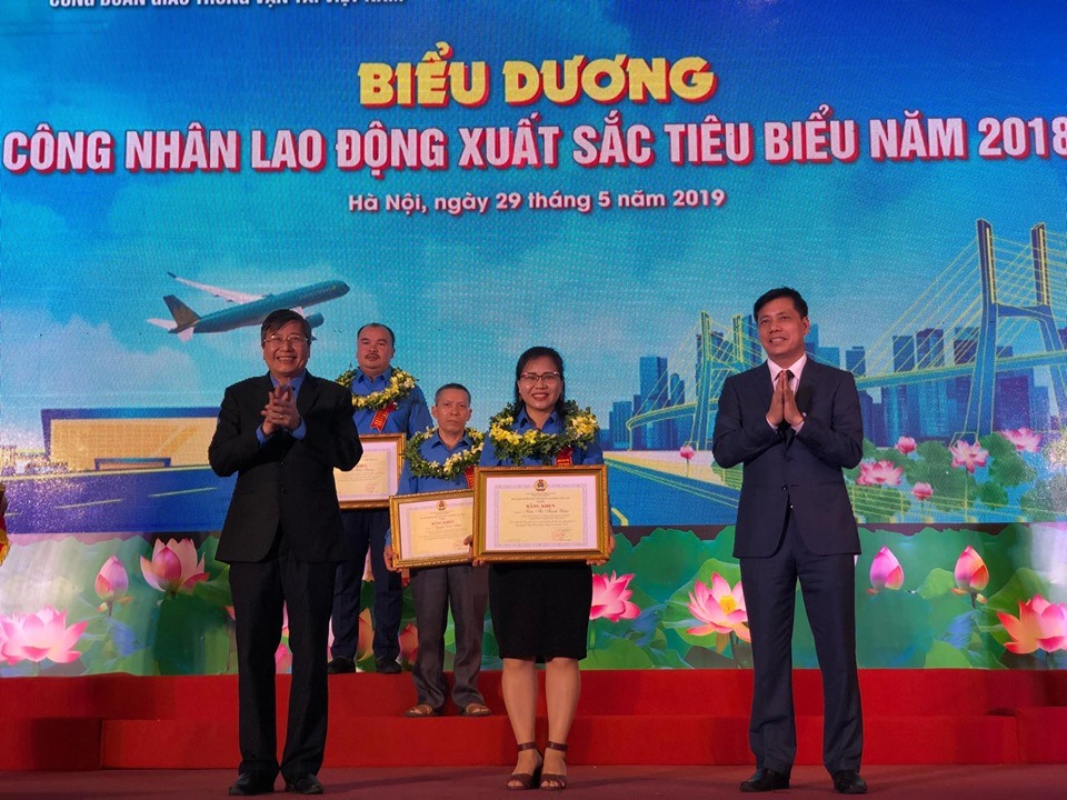Đồng chí Trần Thanh Hải - Phó Chủ tịch Thường trực Tổng LĐLĐVN và đồng chí Nguyễn Ngọc Đông - Thứ trưởng Bộ GTVT cùng trao Bằng khen và vòng hoa cho CNLĐ xuất sắc tiêu biểu năm 2018. Ảnh: Đ.P