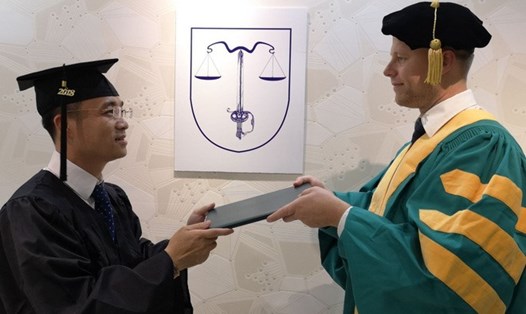Ông Lê Hoàng Anh Tuấn (trái) nhận bằng Tiến sĩ Triết học danh dự chuyên ngành “Ngôn ngữ học”. Ảnh: Marie Leova