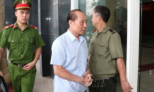 Cảnh sát dẫn giải bị cáo Phan Hữu Tuấn - cựu Trung tướng, Phó Tổng cục trưởng Tổng cục V, Bộ Công an -  vào phòng xét xử. Ảnh: TTXVN