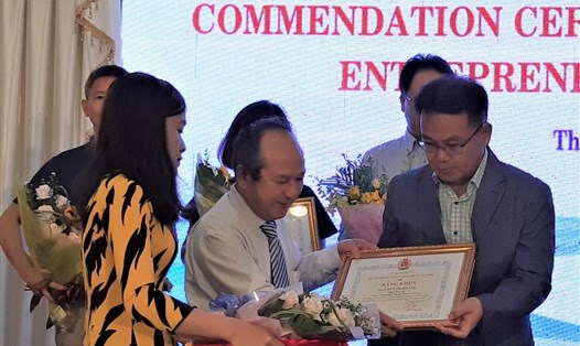 Ông Nguyễn Hoàng Năng, Thành ủy viên, Trưởng Ban Quản lý các KCX&CN TPHCM tặng Bằng khen cho chủ DN. Ảnh Nam Dương