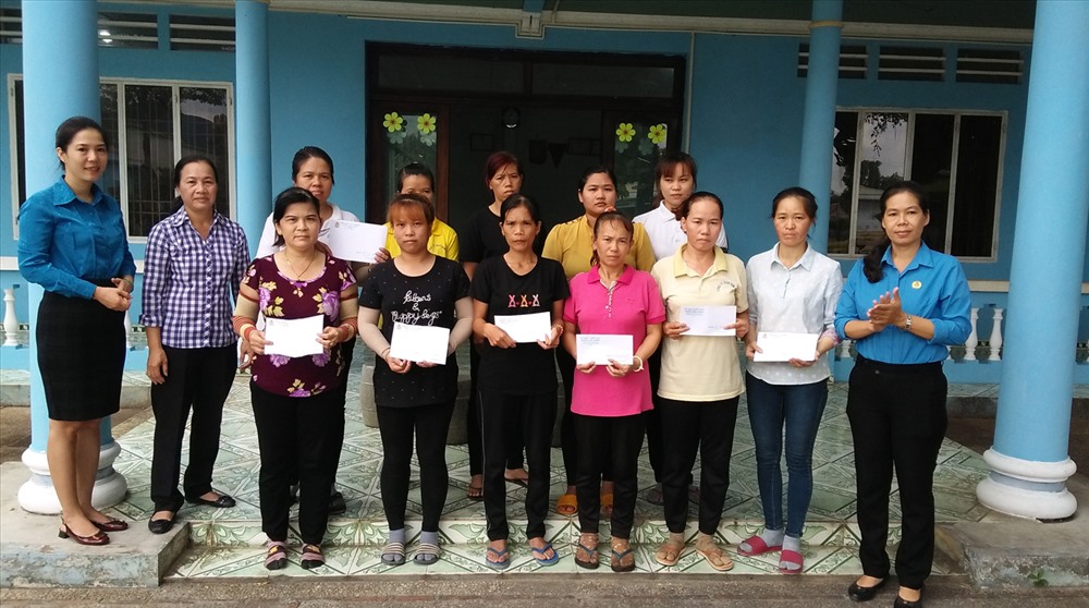 Phó Chủ tịch LĐLĐ huyện Trần Lê Thị Ngọc Hạnh (bên phải, ngoài cùng) tặng quà cho CNLĐ khó khăn.