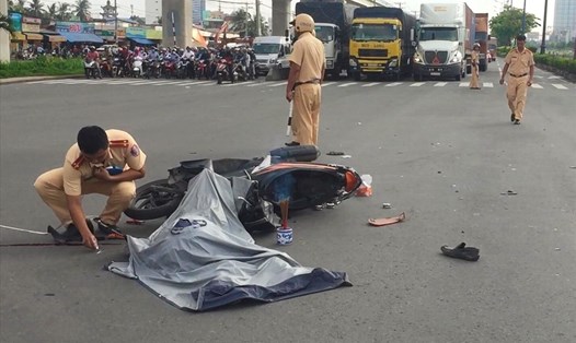 Cảnh sát giao thông khám nghiệm hiện trường vụ tai nạn giao thông trên Xa lộ Hà Nội sáng 14.6.  Ảnh: G.A