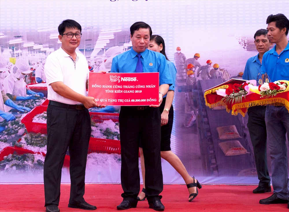 Ông Trần Thanh Việt - Chủ tịch LĐLĐ Kiên Giang - tiếp nhận bản tượng trưng 180 hộp sữa Neslté Việt Nam từ Quỹ Tấm lòng vàng Lao Động. Ảnh: P.V