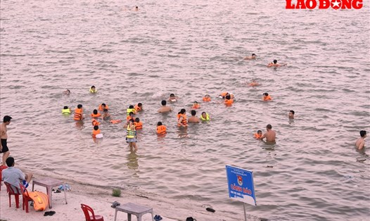Người dân T.P Vinh đổ xô ra Sông Lam tắm giải nhiệt. Ảnh: Bích Dũng