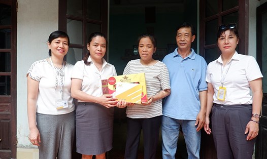 Phó Chủ tịch Công đoàn TCty Bưu điện Việt Nam Lê Thị Hà (thứ hai từ trái sang) trao quà cho đoàn viên có hoàn cảnh khó khăn. Ảnh: T.T