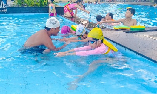 Các HLV hướng dẫn cho các em học bơi. ảnh: V.X