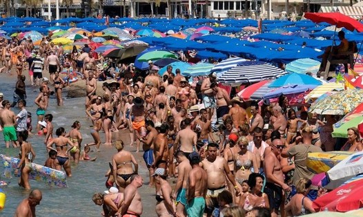 Nắng nóng khiến các bãi biển đông nghịt người. Ảnh: Reuters