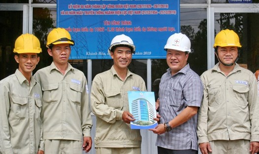 Ông Nguyễn Mạnh Thông chủ tịch Công đoàn công ty Điện lực Khánh Hòa và CBCN trạm biến áp 110KV-E30 găn biển công trình chào mừng 90 năm thành lập Công đoàn Việt Nam. Ảnh: P.L