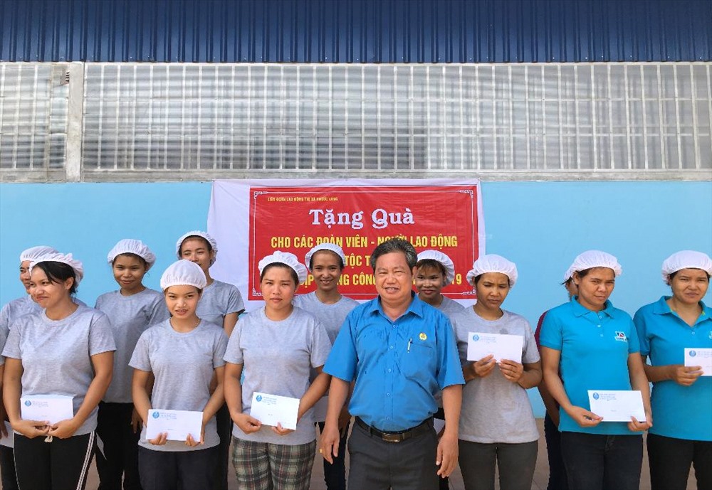Chủ tịch LĐLĐ thị xã Phước Long - Nguyễn Văn Lâm tặng quà cho người lao động dân tộc thiểu số có hoàn cảnh khó khăn. Ảnh S.H