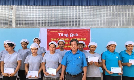 Chủ tịch LĐLĐ thị xã Phước Long - Nguyễn Văn Lâm tặng quà cho người lao động dân tộc thiểu số có hoàn cảnh khó khăn. Ảnh S.H