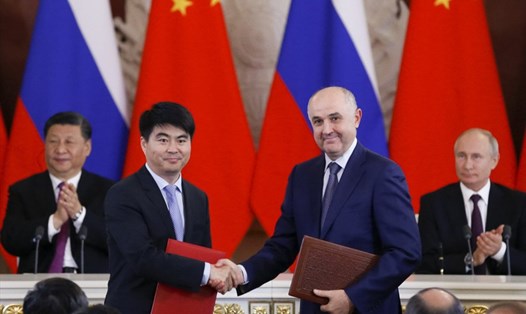Guo Ping - Phó Chủ tịch Huawei (trái) và Chủ tịch MTS Alexei Kornya bắt tay sau khi ký thỏa thuận trước sự chứng kiến của Tổng thống Nga Vladimir Putin và Chủ tịch Trung Quốc Tập Cận Bình. Ảnh: AP