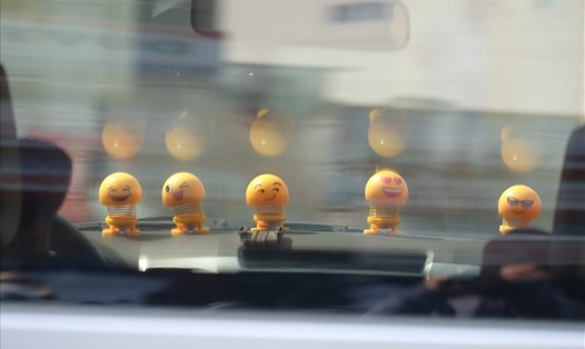 Thú nhún Emoji được đặt trên táp lô của xe ô tô. ảnh: H.V