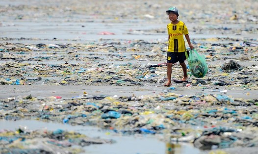 Một cậu bé mưu sinh bằng việc nhặt phế liệu trên bãi biển ở Bình Thuận. Ảnh: Nguyễn Việt Hùng.