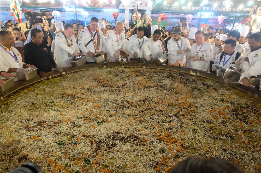 Các đầu bếp đang bỏ các nguyên liệu chiếc bánh xèo.