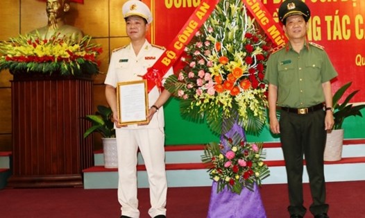 Đại tá Trần Hải Quân (bên trái) nhận quyết định Giám đốc Công an tỉnh Quảng Bình. Ảnh: Lê Phi Long