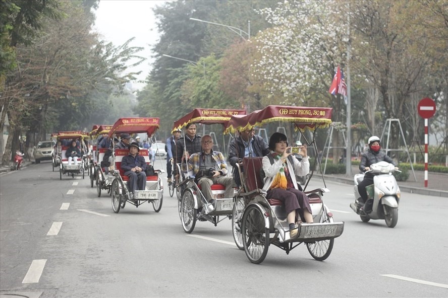 Du khách du lịch bằng xe xích lô quanh khu vực bờ hồ. Ảnh PV