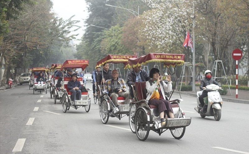 Du khách du lịch bằng xe xích lô quanh khu vực bờ hồ. Ảnh PV