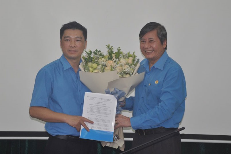 Đồng chí Trần Thanh Hải- Phó Chủ tịch Thường trực Tổng LĐLĐVN - trao Quyết định và tặng hoa chúc mừng đồng chí Hoàng Ngọc Tú. Ảnh: Quế Chi